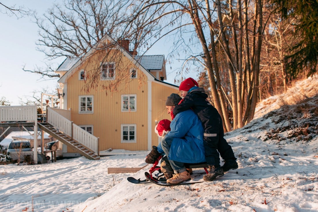 family sledging in their garden in sweden