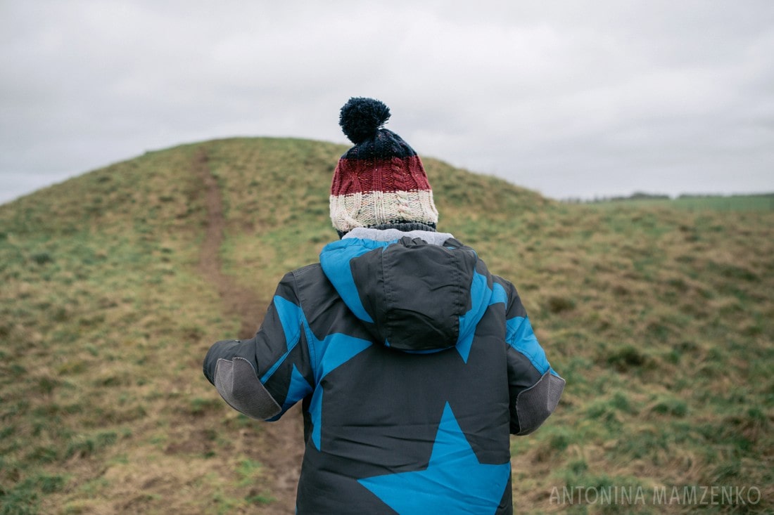 climbing up burial hills at stonehenge