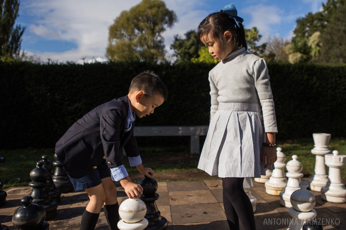 brother and sister playing chess in holland park