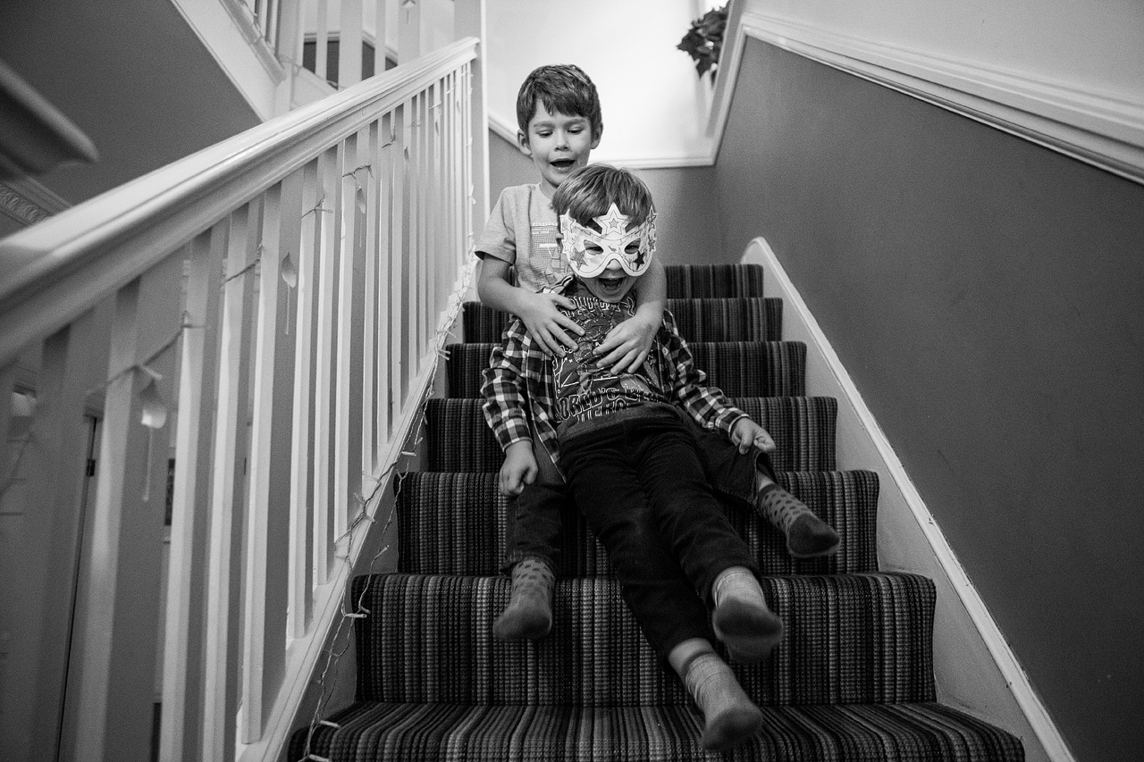 brothers riding down the staircase having fun