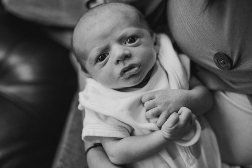black and white portrait of a newborn baby looking at the camera